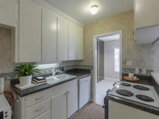 a kitchen with sink a stove and cabinets