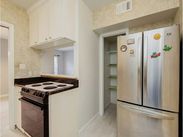 a kitchen with stainless steel appliances granite countertop a refrigerator and a stove