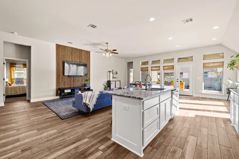 a living room with granite countertop furniture and a wooden floor