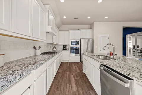 a large kitchen with granite countertop lots of counter space and a sink