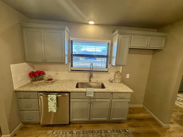 a view of an empty room and window and chandelier fan