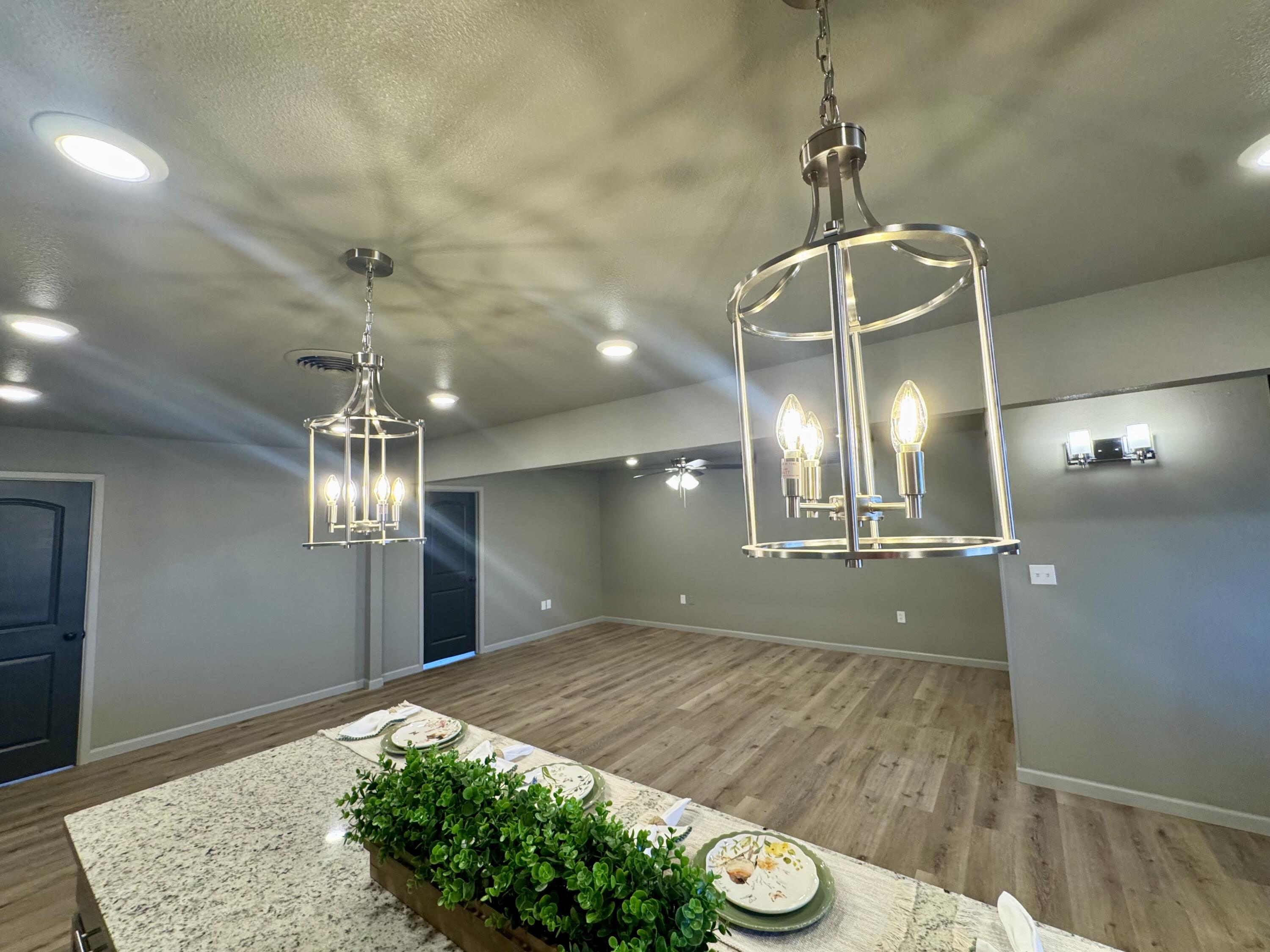 106 North 22nd Place Lamesa, TX 79331 - Photo 25 of 82 a view of a room with a chandelier fan and wooden floor