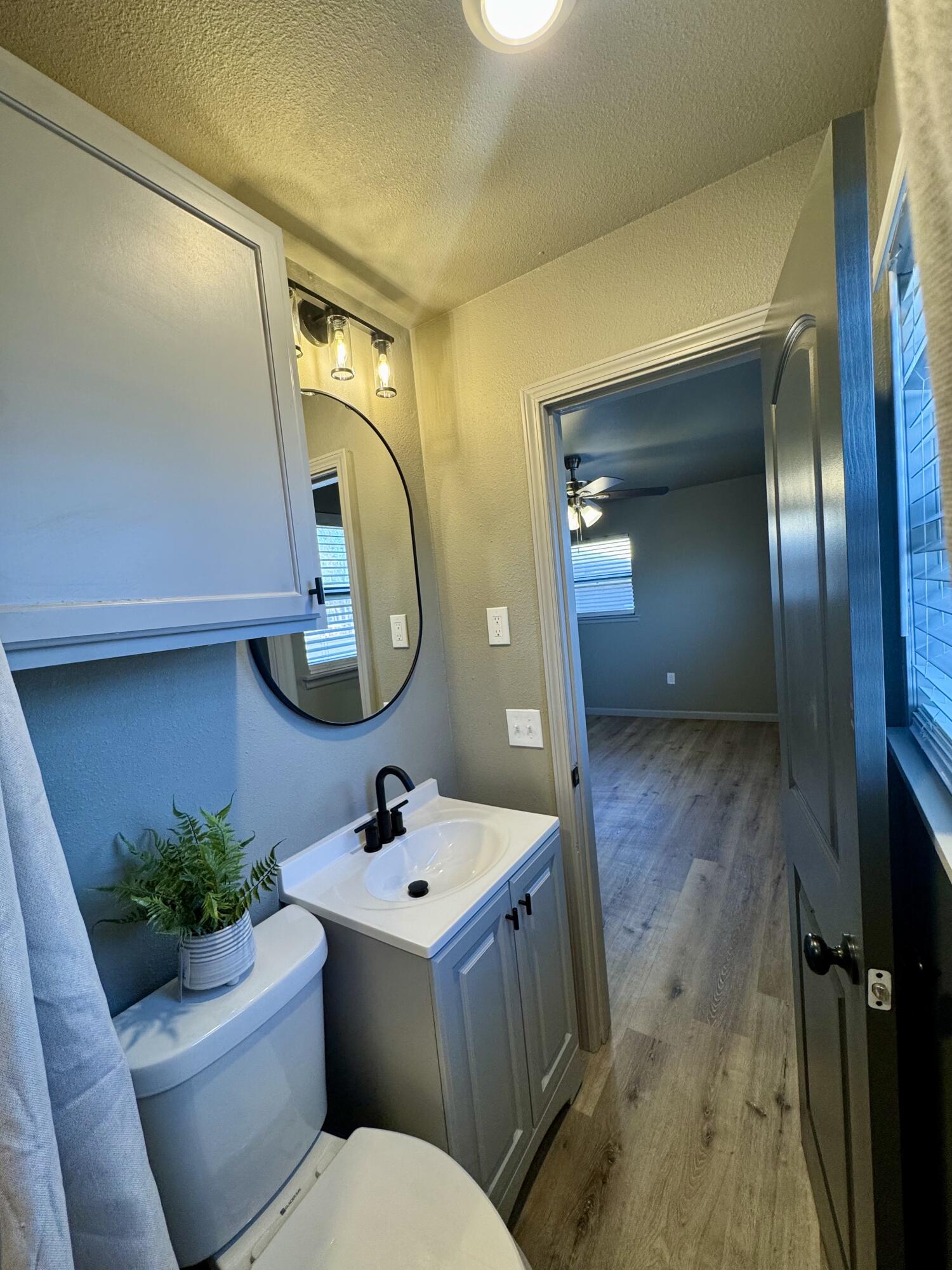 106 North 22nd Place Lamesa, TX 79331 - Photo 45 of 82 a bathroom with a toilet a sink and mirror