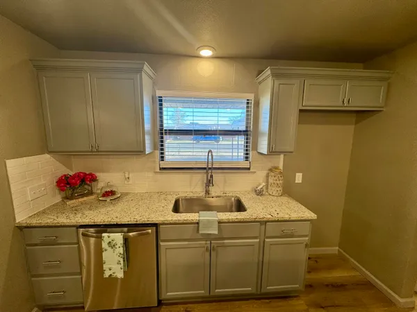 a bathroom with a toilet sink vanity granite and mirror