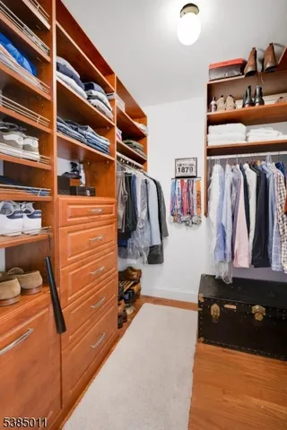a view of walk in closet with clothes and shoes