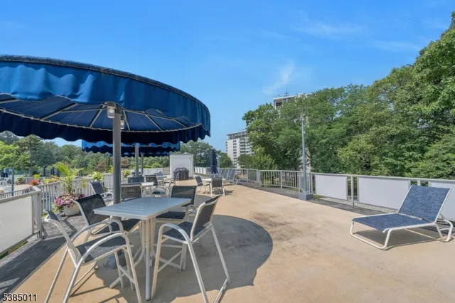 a patio with a table and chairs under an umbrella