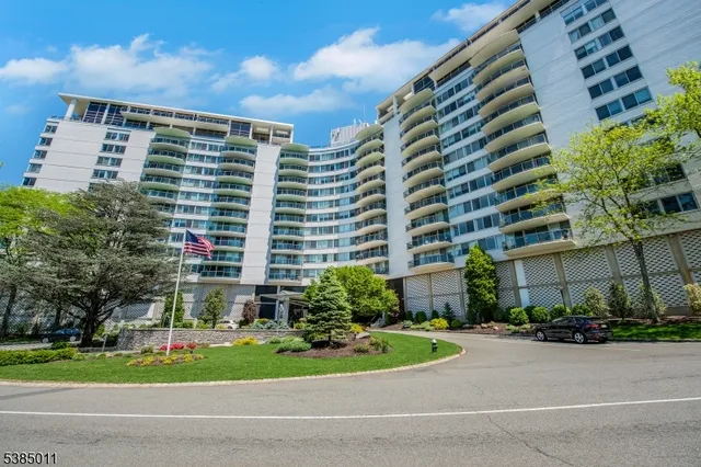 a front view of a residential apartment building with a yard and plants