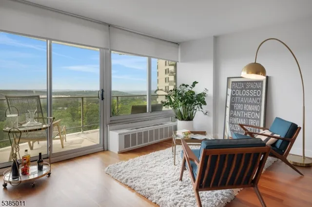 a living room with furniture and a floor to ceiling window