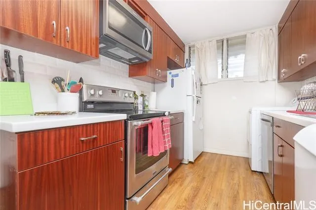 a kitchen with stainless steel appliances granite countertop a lot of cabinets a sink and wooden floor