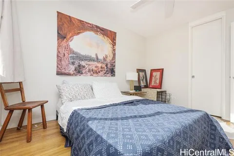 a bedroom with a bed and a painting on the wall