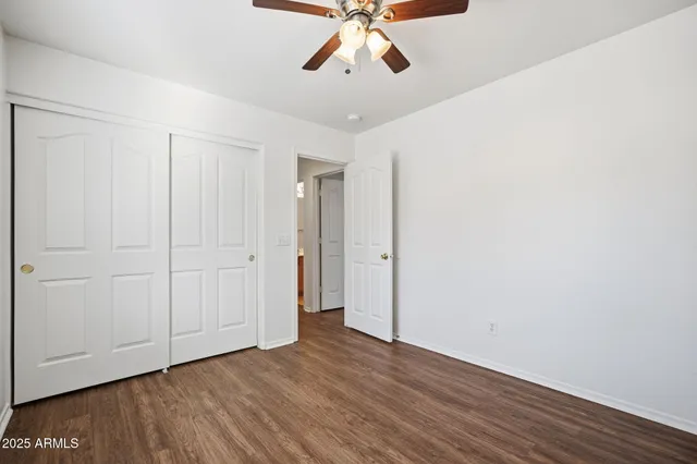 an empty room with a window and a fan