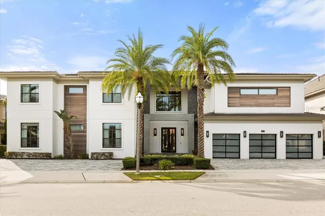 a view of a house with a yard and palm trees