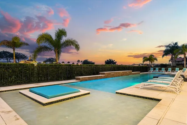 a kitchen with stainless steel appliances kitchen island granite countertop a dining table chairs and a refrigerator