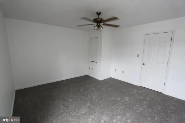 a view of an empty room and a ceiling fan