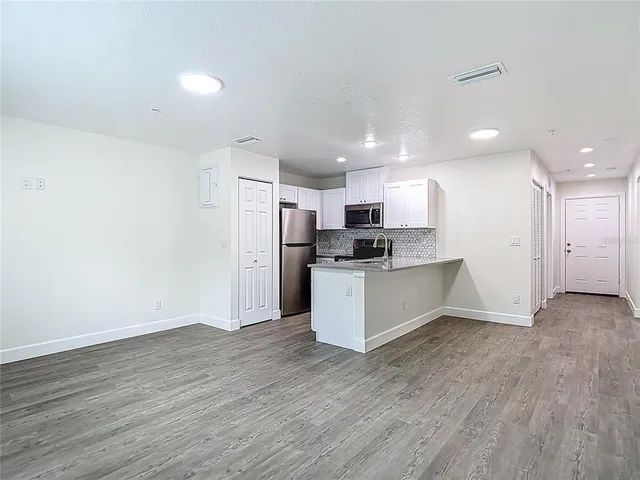 a kitchen with granite countertop a sink stainless steel appliances and cabinets