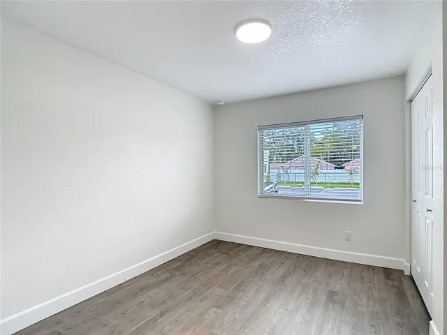 a view of a room with wooden floor and a window