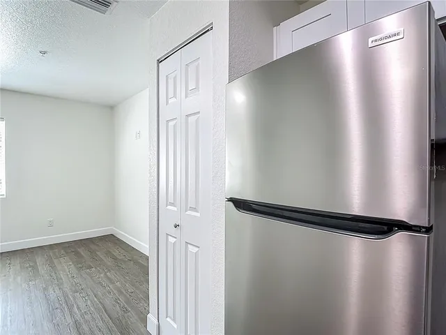 a view of a room with wooden floor and white walls