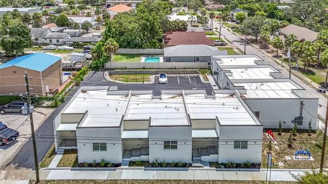 a front view of a house with lots of windows and plants
