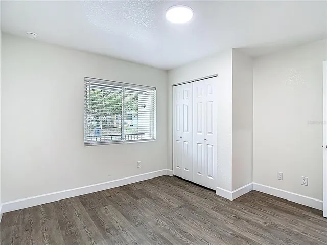 an aerial view of a red and white house with a yard and potted plants