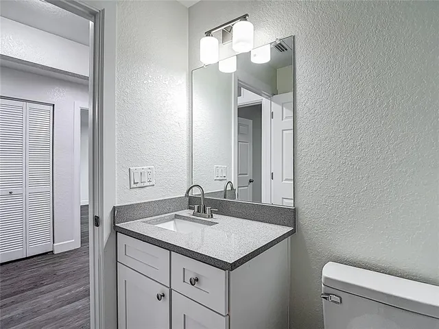 a front view of a house with a yard and a large tree