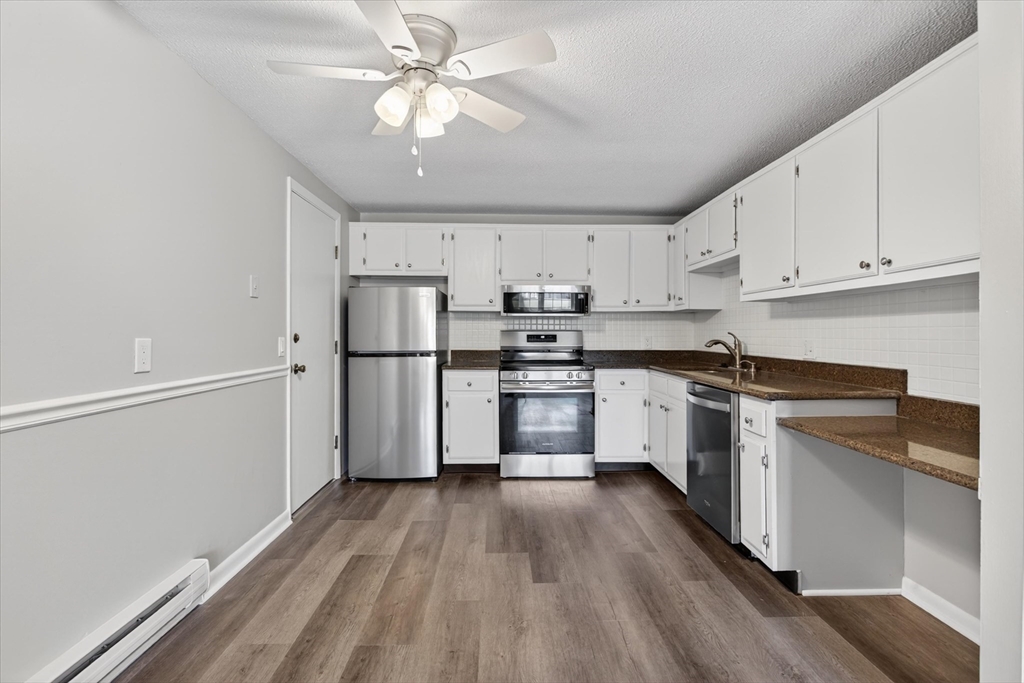 a kitchen with white cabinets stainless steel appliances and a window