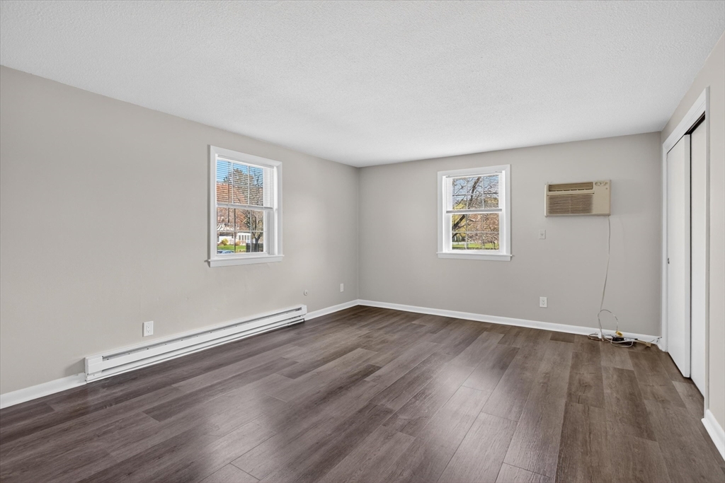 91 Pleasant Street, Unit A6 Medfield, MA 02052 - Photo 11 of 17 an empty room with wooden floor and windows
