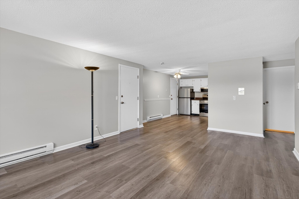 91 Pleasant Street, Unit A6 Medfield, MA 02052 - Photo 3 of 17 a view of empty room with wooden floor