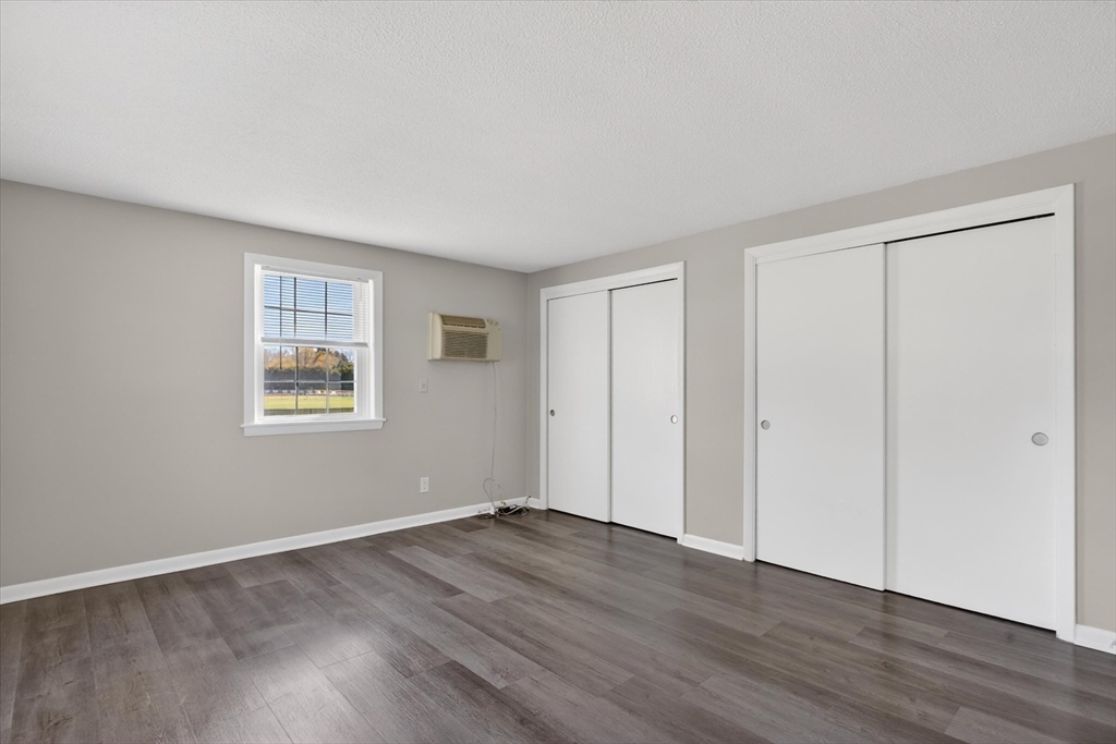 91 Pleasant Street, Unit A6 Medfield, MA 02052 - Photo 9 of 17 a view of an empty room with wooden floor and a window