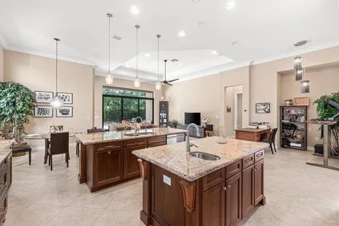 a view of a kitchen with kitchen island a stove a counter top space appliances and a center island