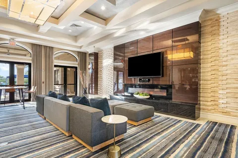 a living room filled with lots of furniture and a large window