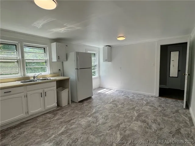 a kitchen with a refrigerator sink and cabinets