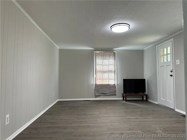 an empty room with windows and fireplace