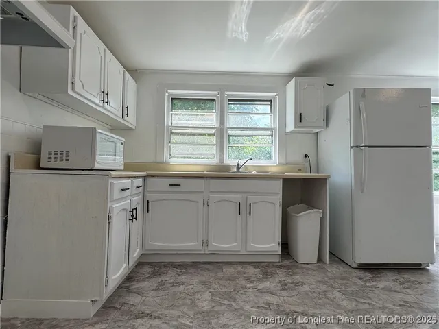 a kitchen with white cabinets and white appliances
