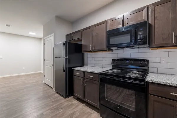 a kitchen with stainless steel appliances a stove a microwave a sink and cabinets