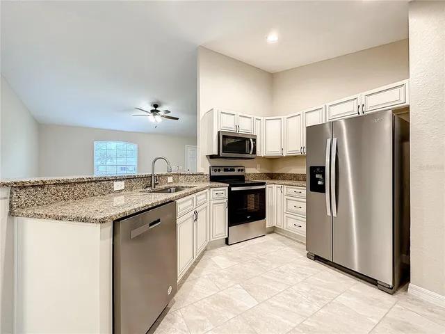a kitchen with stainless steel appliances granite countertop a refrigerator stove and microwave
