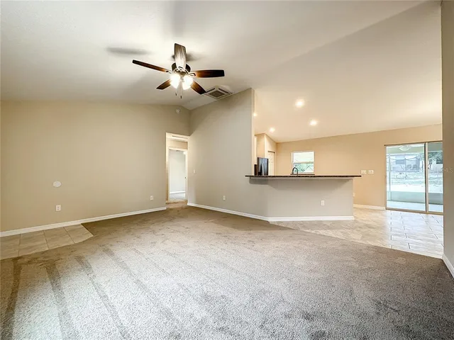 an empty room with a ceiling fan and a window