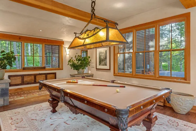 a room with pool table and windows