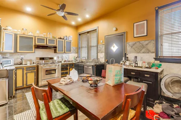 a kitchen with a sink a stove and chairs