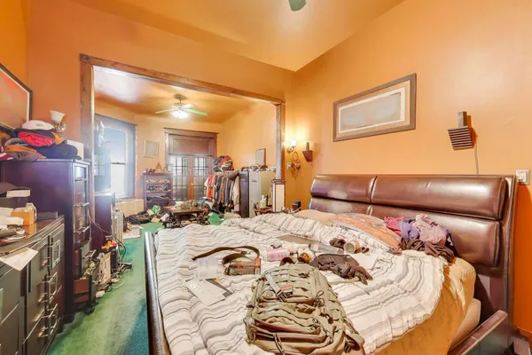 a bed sitting in a bedroom next to a window with kitchen