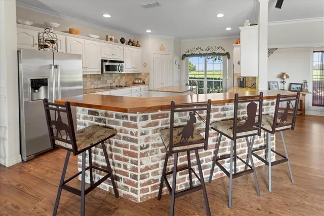 a kitchen with granite countertop white cabinets and stainless steel appliances