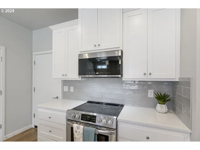 a kitchen with granite countertop white cabinets and white appliances