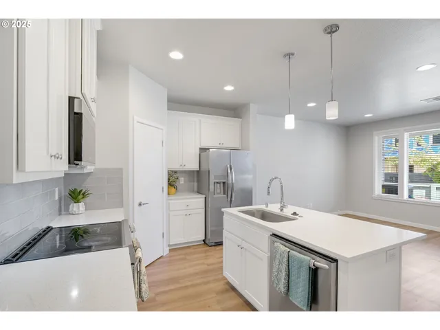 a kitchen with kitchen island a sink stainless steel appliances and window