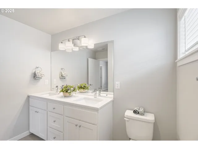 a bathroom with a sink a toilet a mirror and shower