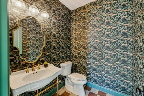 a bathroom with a sink toilet and a mirror