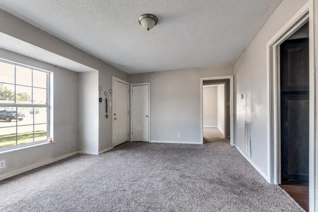 an empty room with windows and closet