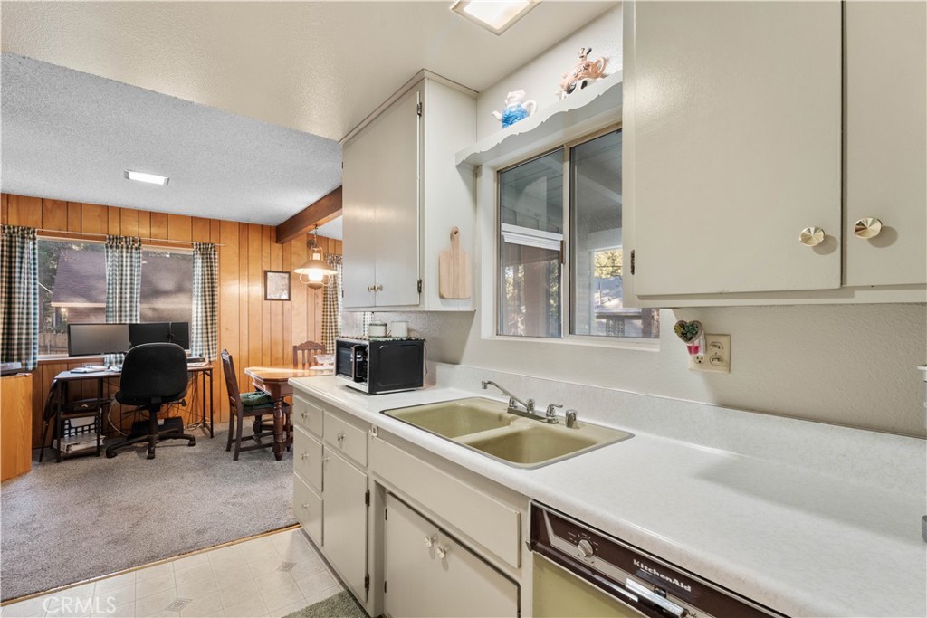 1130 Robin Road Wrightwood, CA 92397 - Photo 13 of 34 a view of a kitchen with kitchen island a sink stainless steel appliances wooden floor and a large window