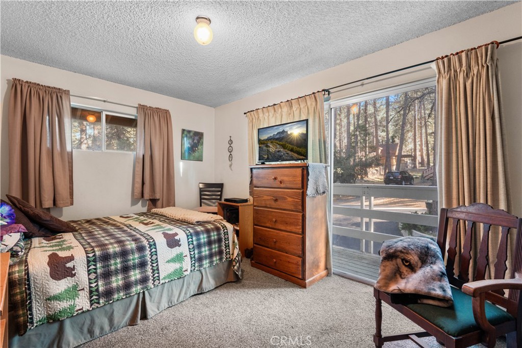 1130 Robin Road Wrightwood, CA 92397 - Photo 24 of 34 a bedroom with a bed and large windows