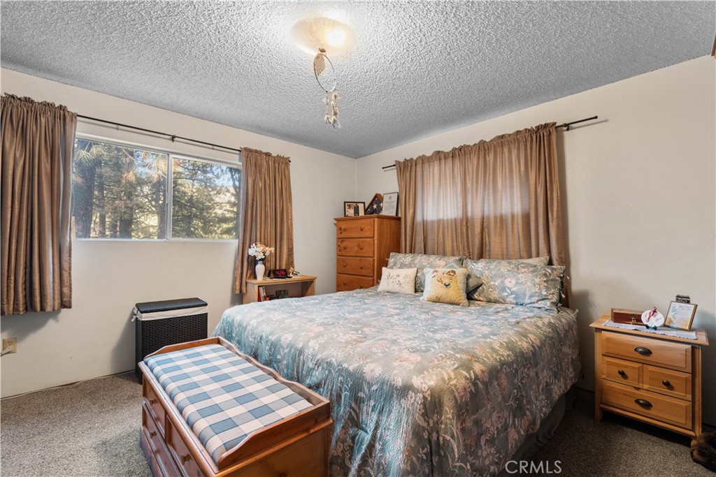 1130 Robin Road Wrightwood, CA 92397 - Photo 26 of 34 a bedroom with a bed and a dresser