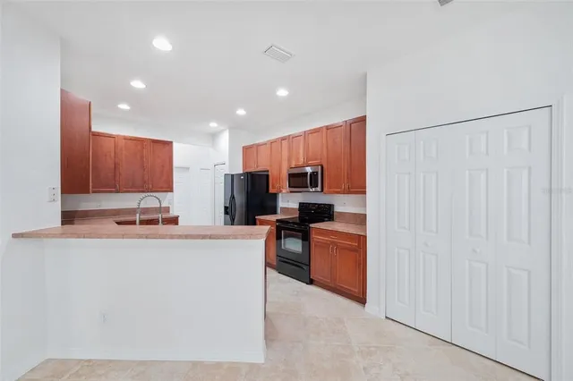 a kitchen with stainless steel appliances granite countertop a refrigerator oven a sink dishwasher and a refrigerator with wooden cabinets