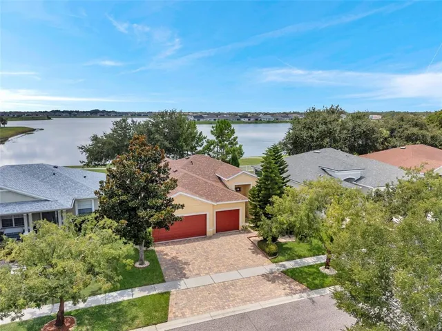 an aerial view of a house with a garden and lake view